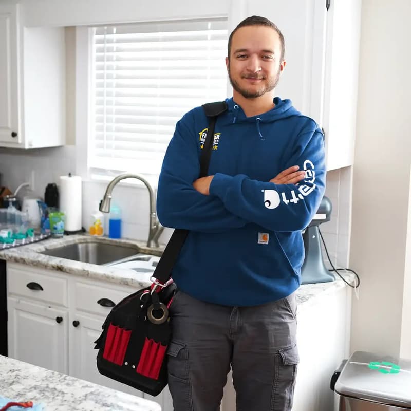 Technician with arms crossed in a customer kitchen