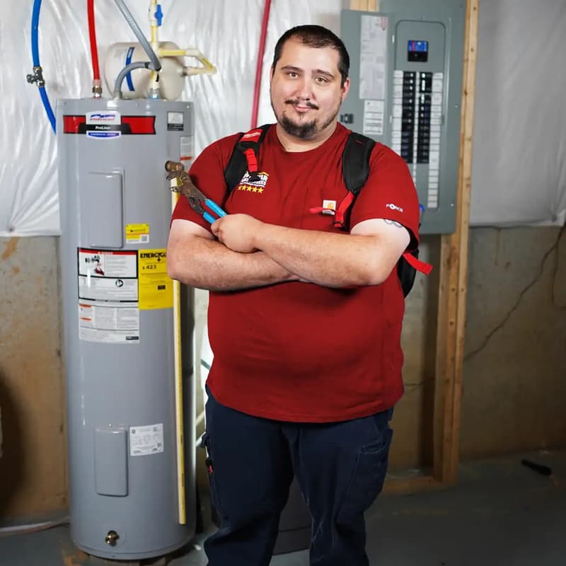 Technician standing next to electric water heater in basement